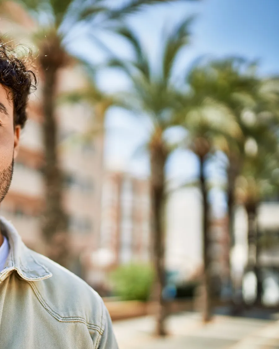 Hombre latino sonriente y esperanzado al aire libre